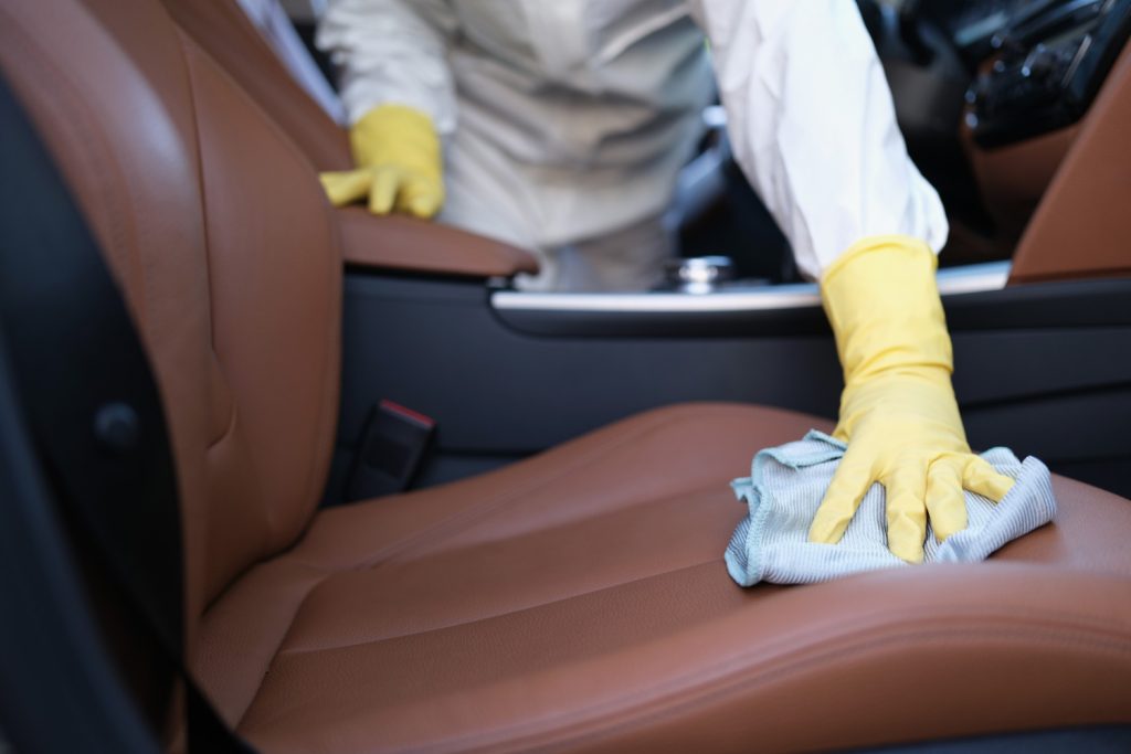 man polishing luxury leather interior car